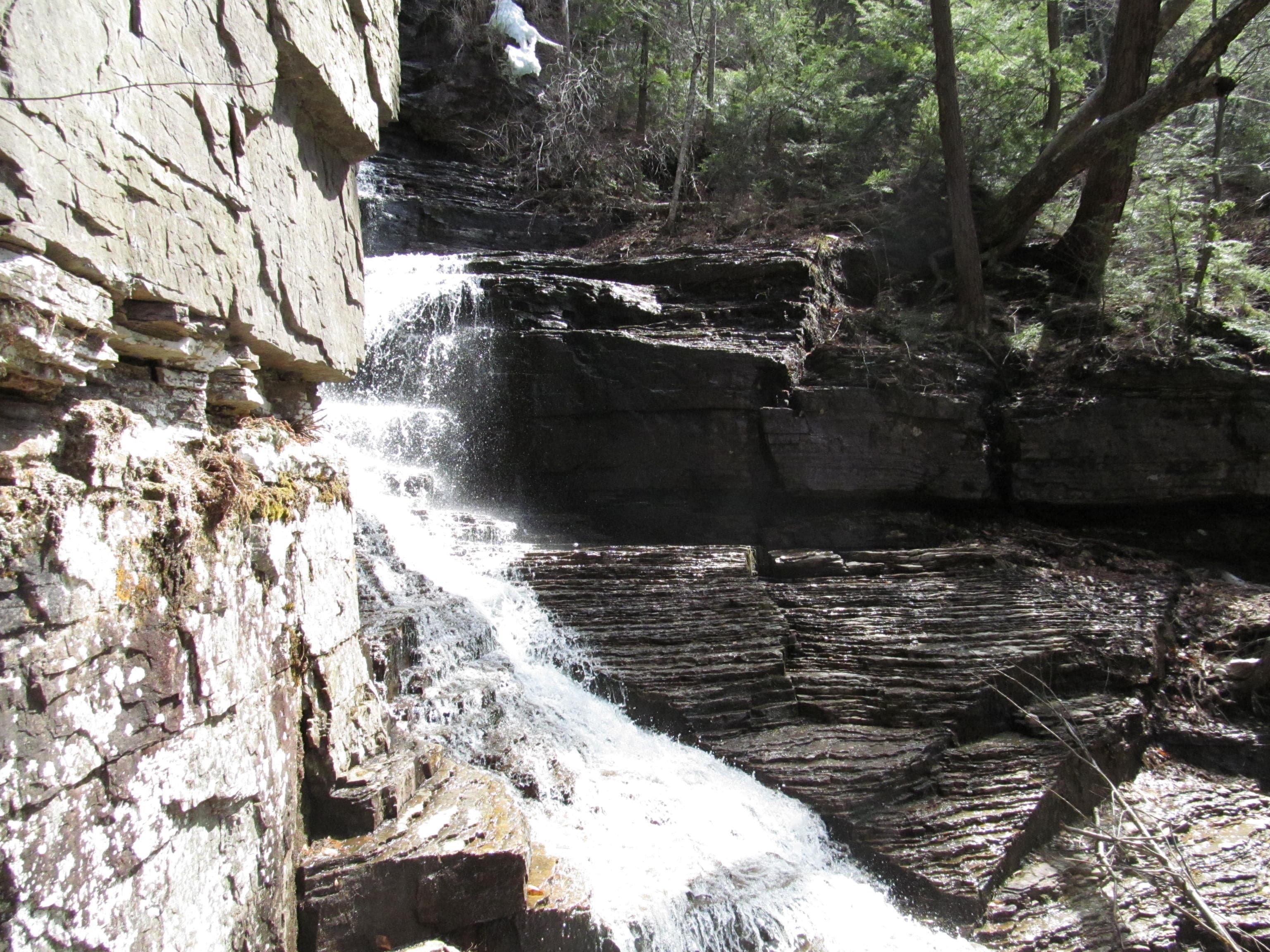Lower cascade at Lye Brook Falls near Manchester, Vermont, pouring past a pale rock wall into layered ledges.